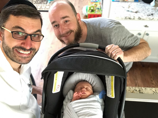 Parent and surgeon posing with a baby 1 week after circumcision
