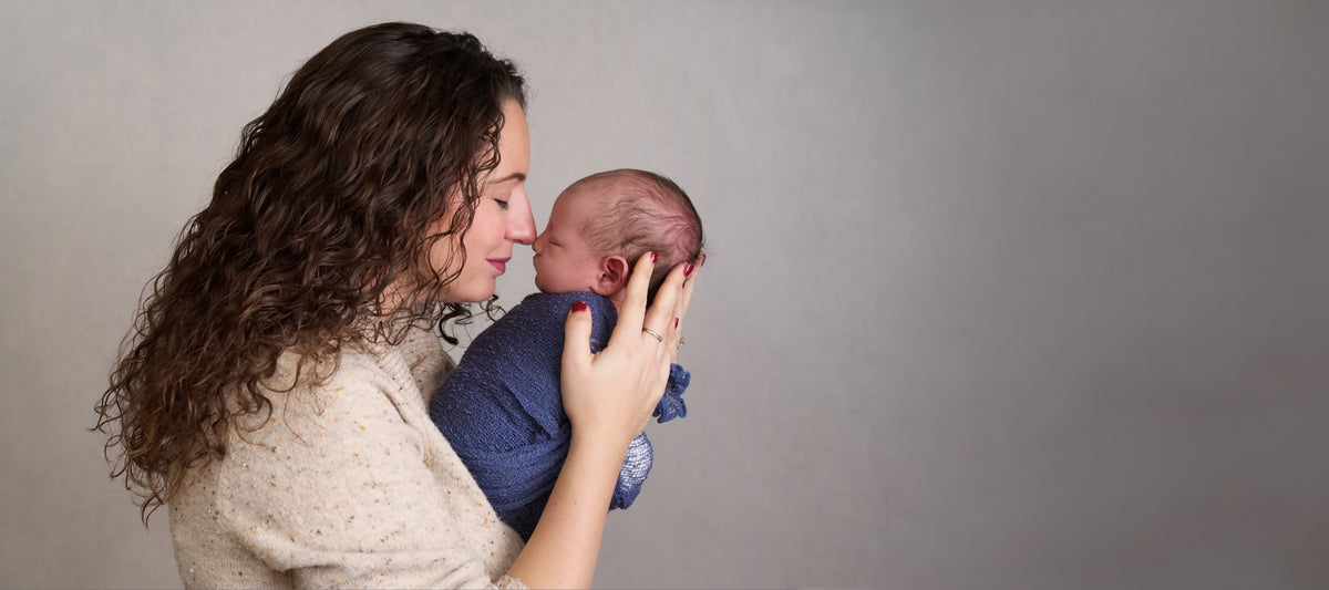 A mother holding her newborn at home